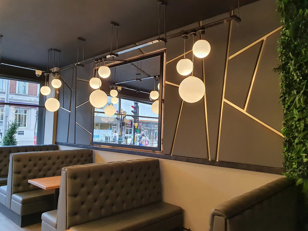 Restaurant dining area with upholstered booth seating, pendant lighting and dining tables
